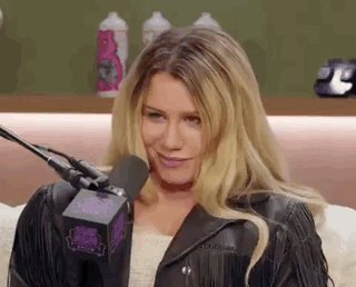 A Woman Is Sitting In Front Of A Microphone . GIF