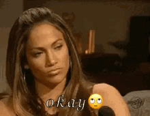 A Woman Is Sitting In Front Of A Microphone And Saying Okay GIF