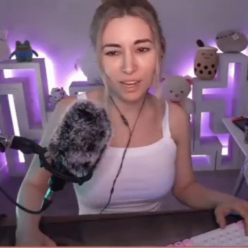 A Woman Is Sitting In Front Of A Microphone In A Room . GIF