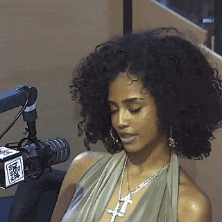 A Woman Is Sitting In Front Of A Microphone With A Box That Says Fox GIF