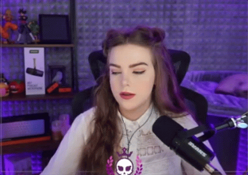 A Woman Is Sitting In Front Of A Shure Microphone In A Recording Studio . GIF