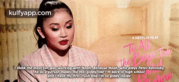 A Woman Is Sitting In Front Of A Sign That Says I Think The Most Fun Was Working With Noah GIF