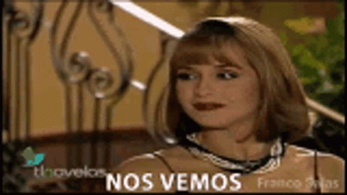 A Woman Is Sitting In Front Of A Wrought Iron Railing With The Words Nos Vemos On The Bottom GIF