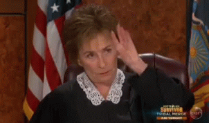 A Woman Is Sitting In Front Of An American Flag And A Sign That Says Survivor Tonight GIF