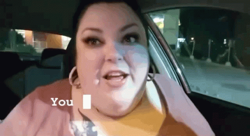 A Woman Is Sitting In The Back Seat Of A Car And Talking To Someone . GIF