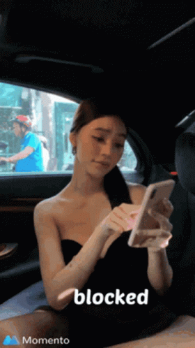 A Woman Is Sitting In The Back Seat Of A Car Looking At Her Phone And The Word Blocked Is On The Bottom Right GIF
