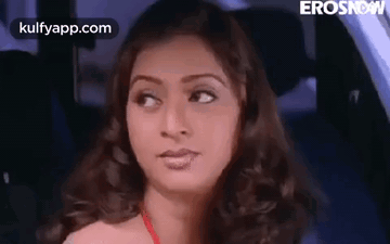 A Woman Is Sitting In The Back Seat Of A Car . GIF