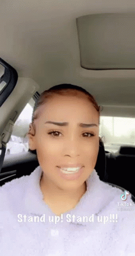 A Woman Is Sitting In The Back Seat Of A Car With A Caption That Says Stand Up ! Stand Up !! GIF