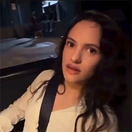 A Woman Is Sitting In The Back Seat Of A Car With A Seat Belt . GIF