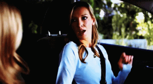 A Woman Is Sitting In The Back Seat Of A Car With Her Mouth Open . GIF