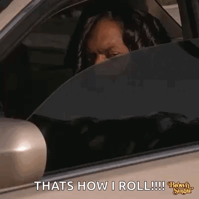 A Woman Is Sitting In The Driver 'S Seat Of A Car And Looking Out The Window . GIF
