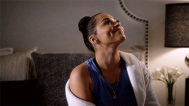 A Woman Is Sitting On A Couch And Looking Up At The Sky . GIF