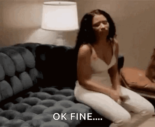A Woman Is Sitting On A Couch And Saying Ok Fine GIF