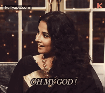 A Woman Is Sitting On A Couch And Says Oh My God GIF