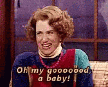 A Woman Is Sitting On A Couch And Smiling While Saying Oh My Goooood , A Baby . GIF
