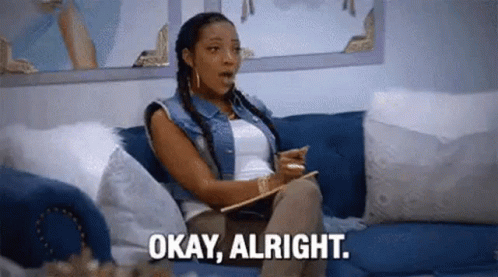 A Woman Is Sitting On A Couch Holding A Clipboard And Saying `` Okay , Alright '' . GIF