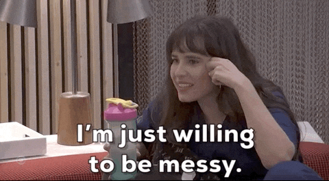 A Woman Is Sitting On A Couch Holding A Shaker And Saying I 'M Just Willing To Be Messy GIF