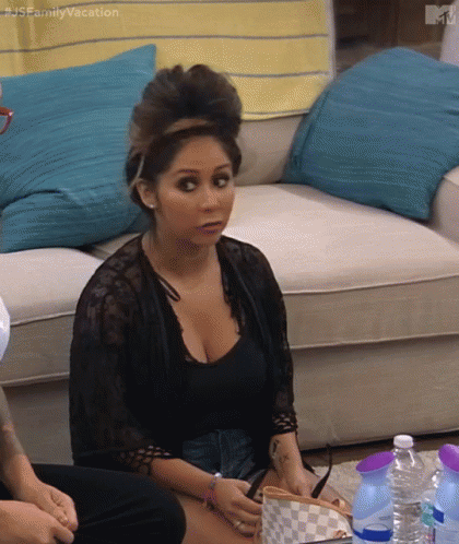 A Woman Is Sitting On A Couch In A Living Room With Bottles Of Water . GIF