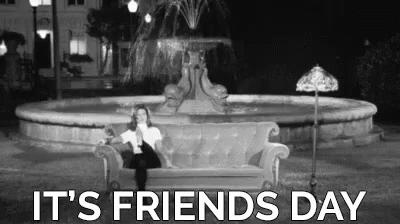 A Woman Is Sitting On A Couch In Front Of A Fountain With The Words `` It 'S Friends Day '' . GIF