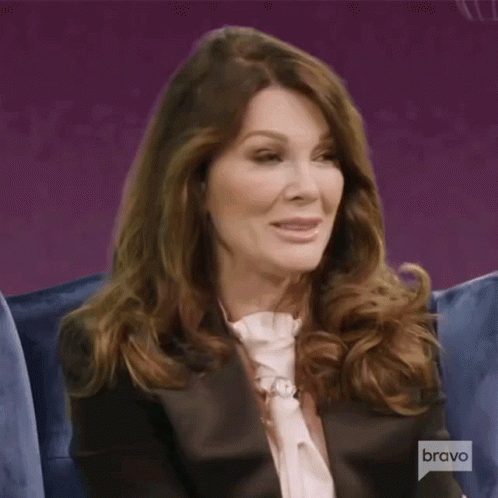 A Woman Is Sitting On A Couch With A Bravo Logo In The Background GIF
