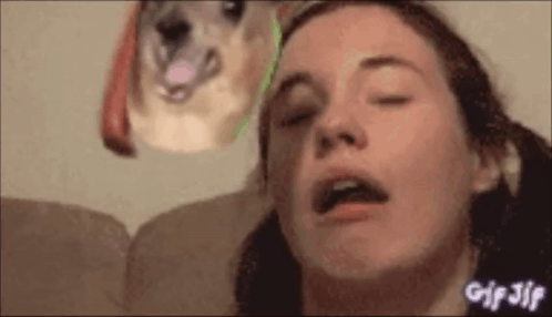 A Woman Is Sitting On A Couch With Her Eyes Closed And A Dog Is Looking At Her . GIF