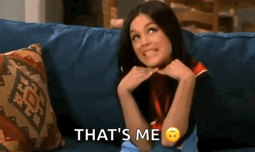 A Woman Is Sitting On A Couch With Her Hands On Her Chin And The Words `` That 'S Me '' . GIF