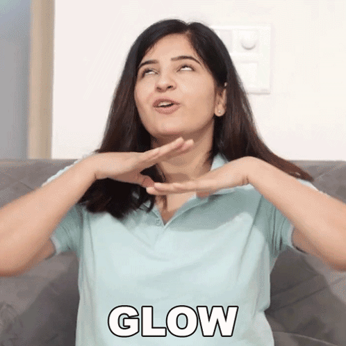 A Woman Is Sitting On A Couch With Her Hands On Her Face And The Word Glow In Front Of Her GIF