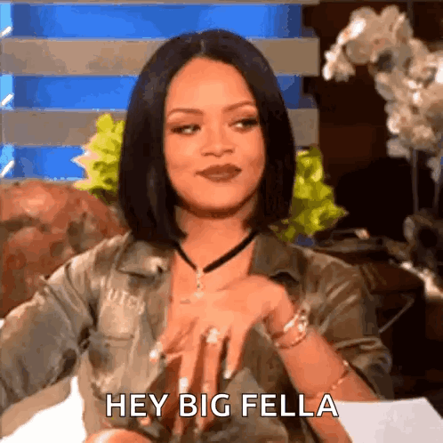 A Woman Is Sitting On A Couch With Her Hands On Her Hips And Says Hey Big Fella . GIF