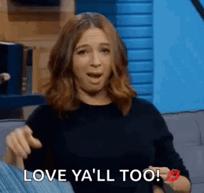 A Woman Is Sitting On A Couch With Her Mouth Open And A Kiss On Her Cheek . GIF