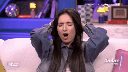Woman Sitting On Couch With Ambre Sign GIF