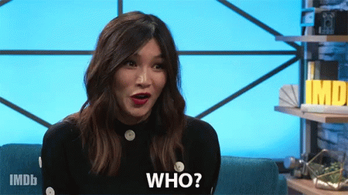 A Woman Is Sitting On A Couch With Her Mouth Open And Says Who GIF
