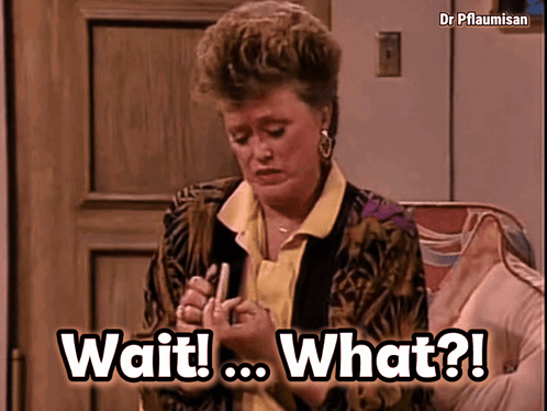 A Woman Is Sitting On A Couch With The Words Wait What Written On The Screen GIF