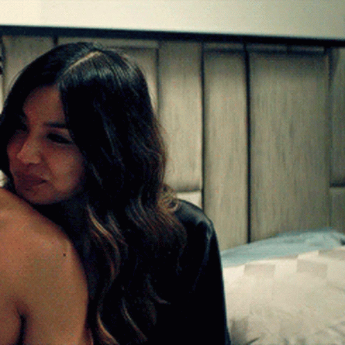 A Woman Is Sitting On A Man 'S Shoulder And Smiling GIF