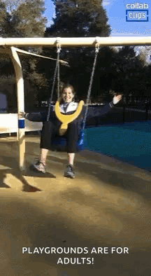 A Woman Is Sitting On A Swing At A Playground And Smiling . GIF