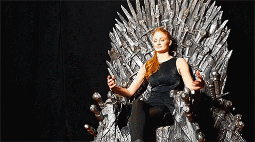 A Woman Is Sitting On A Throne With Her Eyes Closed And Holding A Sword . GIF