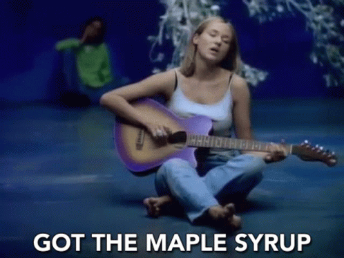 a woman is sitting on the floor playing a purple guitar and singing .