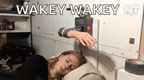 A Woman Is Sleeping In A Bed With A Machine On Her Arm That Says Wakey-Wakey . GIF