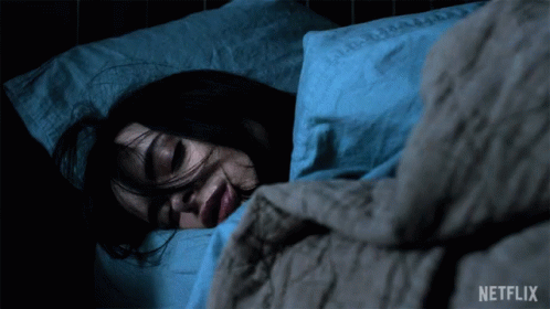 A Woman Is Sleeping In A Bed With A Netflix Logo Behind Her GIF