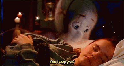 A Woman Is Sleeping In A Bed With A Stuffed Animal Behind Her . GIF