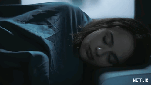 A Woman Is Sleeping In A Dark Room With A Netflix Logo In The Corner GIF