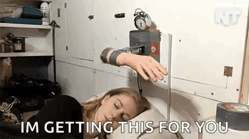 A Woman Is Sleeping In Bed With An Alarm Clock On The Wall Behind Her . GIF