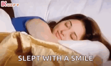 A Woman Is Sleeping With A Smile On Her Face . GIF