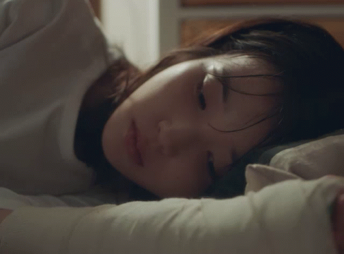 A Woman Is Sleeping With Her Eyes Closed And Her Hair Covering Her Face GIF