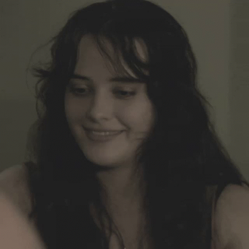 a woman is smiling and holding a cell phone