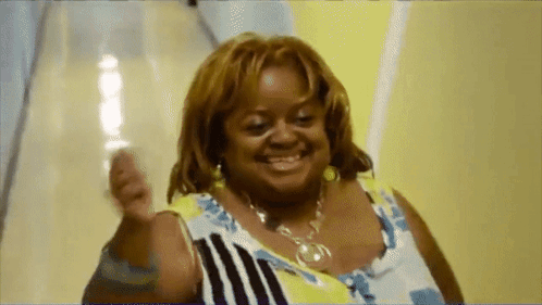 A Woman Is Smiling And Holding A Glass Of Water GIF