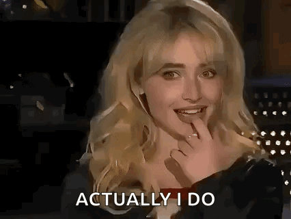 A Woman Is Smiling And Holding Her Hand To Her Mouth While Talking . GIF