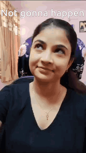 A Woman Is Smiling And Looking Up At The Sky While Wearing A Black Shirt And Necklace . GIF