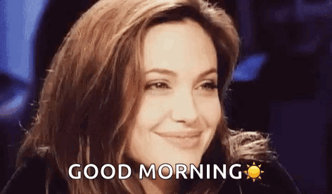 A Woman Is Smiling And Saying `` Good Morning '' With A Sun In The Background . GIF