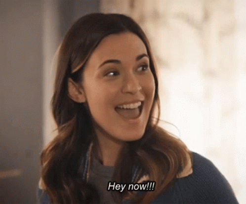 A Woman Is Smiling And Saying Hey Now !!! GIF