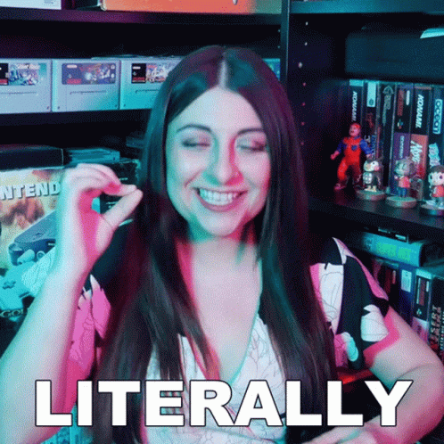 A Woman Is Smiling And Says Literally In Front Of A Video Game Shelf GIF